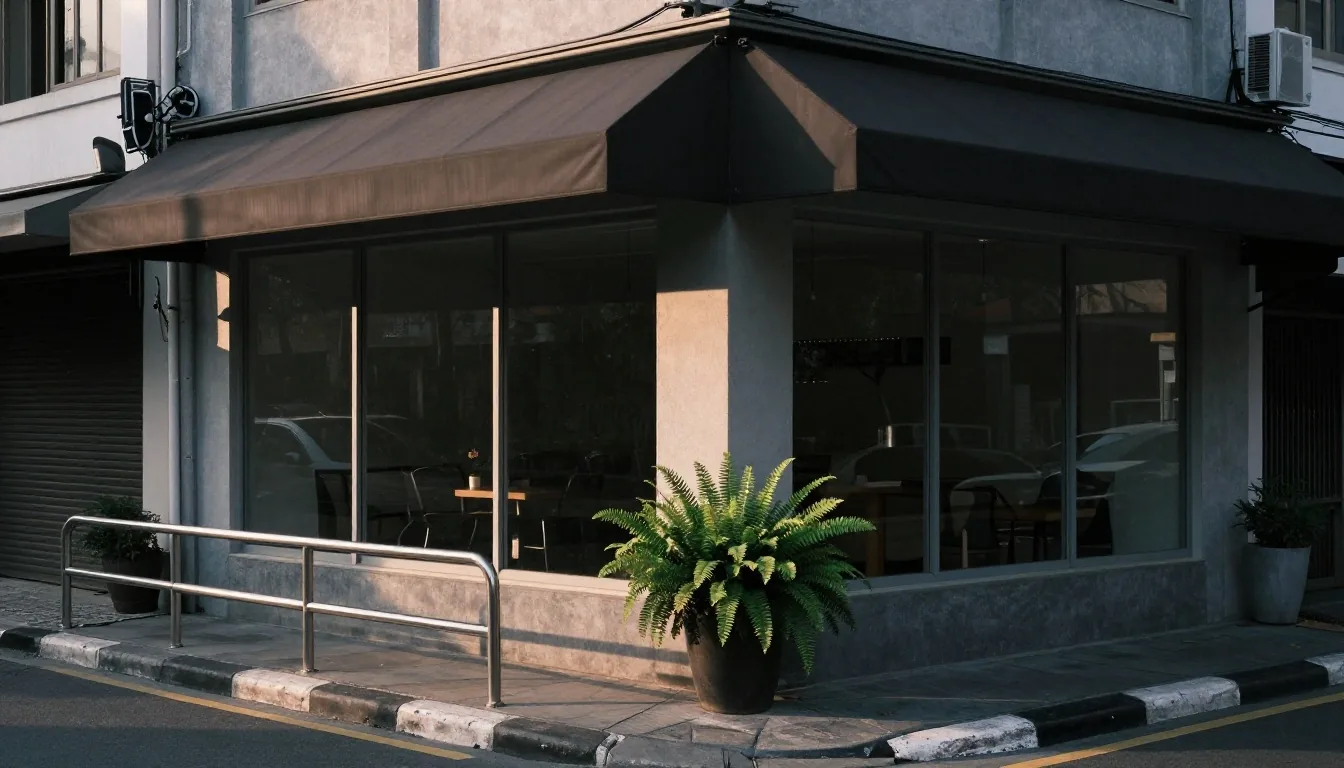 The street outside the LelakiOptimal office on Jl. Braga in Bandung, with a glass front and a fern planter on the pavement